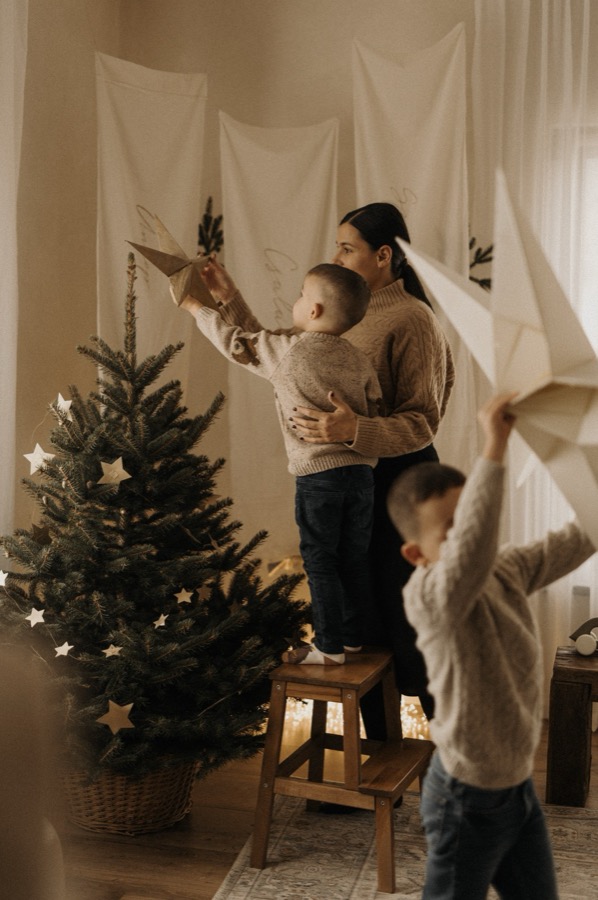Kisfiú a csillagot teszi a fenyő csúcsára